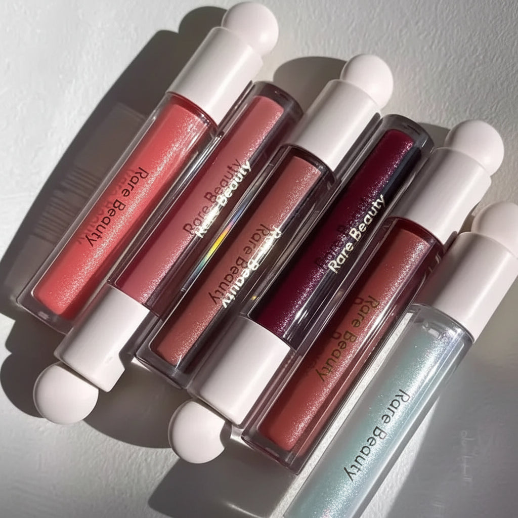 Set of Rare Beauty lip glosses on a light background