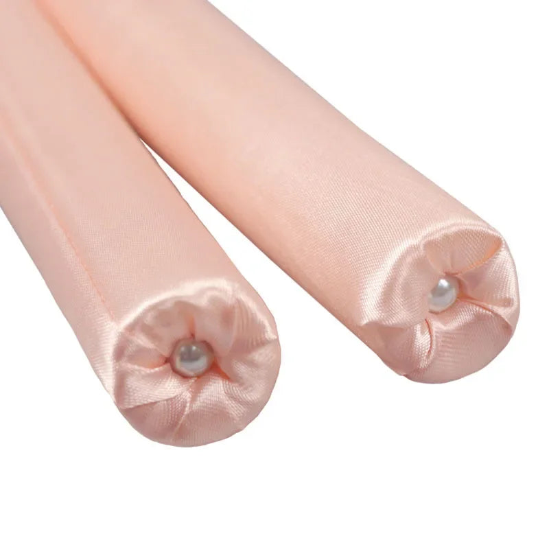 Two pink satin ribbons with pearl centers on a white background
